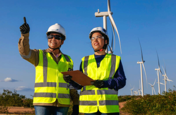 A man and a woman near wind turbines