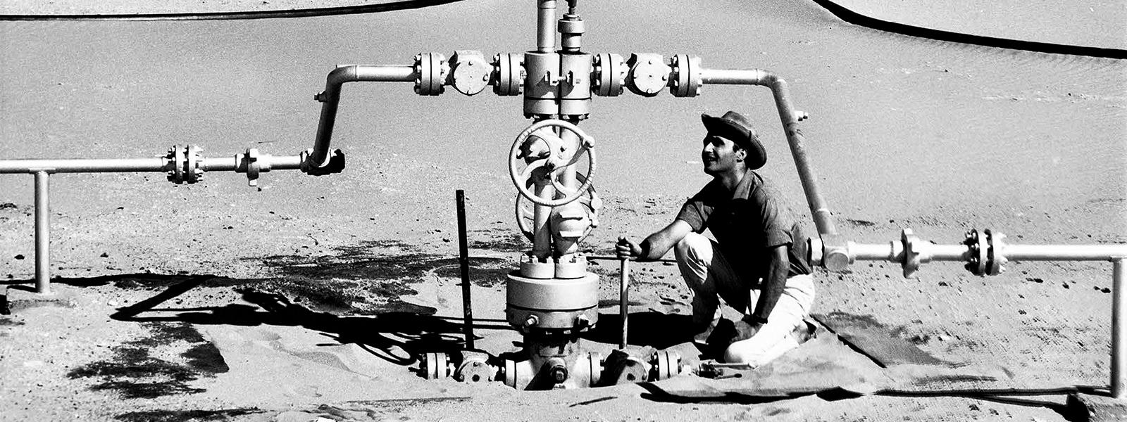 Compagnie de recherche et d'exploitation de pétrole au Sahara (CREPS) - Centrale de détente dans le Sahara - Relevé de pression effectué par un homme accroupi. Elf aquitaine